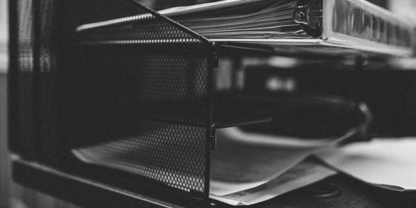 A grayscale closeup shot of folders and papers